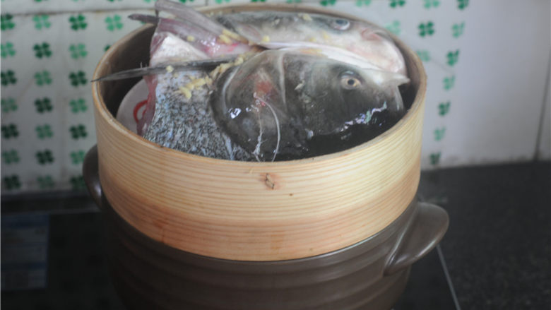 剁椒鱼头,鱼头摆放进蒸笼,放在砂锅上,大火将鱼头先蒸3分钟左右,由于之前抹了盐,鱼头中会析出一些水分,将水笔出
