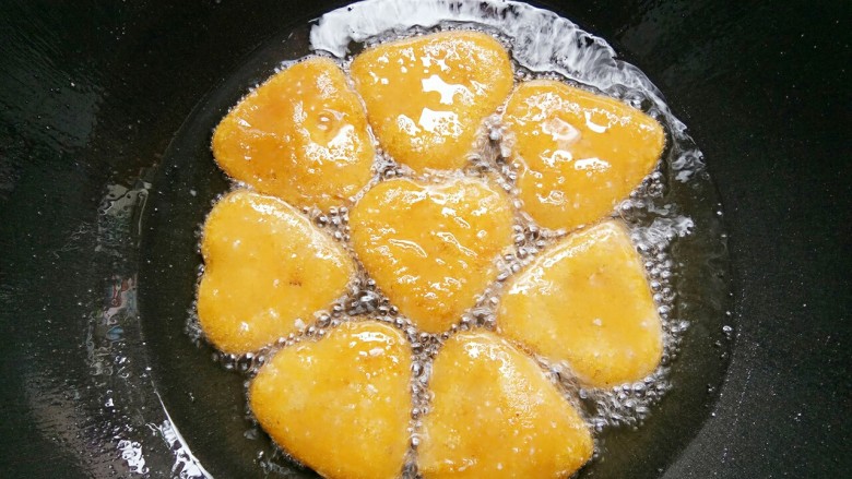 做饼+爱心南瓜饼,锅里放油,油热后转小火放入爱心南瓜饼慢慢煎到两面金黄