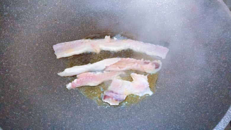 酸菜鱼,锅内倒入油,放入鱼骨煎至两面金黄