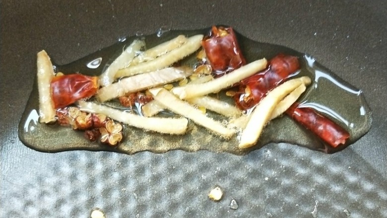 豉香腊肠炒蒜苗,起油锅,放干辣椒,红椒粒,姜丝,小火慢慢煸出香辣味。