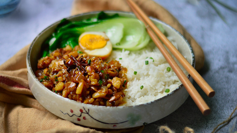 卤肉饭,碗中摆入米饭,摆上青菜、切好的卤蛋和卤肉即可