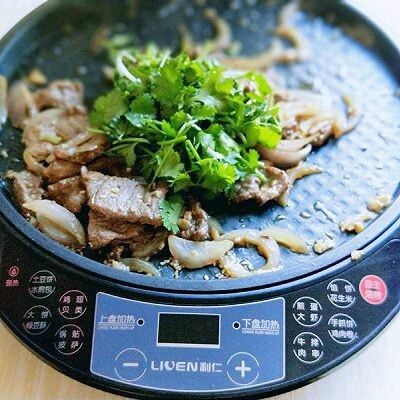 做饼+饼夹鲜嫩牛肉,关火加入切好的香菜,继续翻炒,借助电饼铛的余温将香菜炒熟。