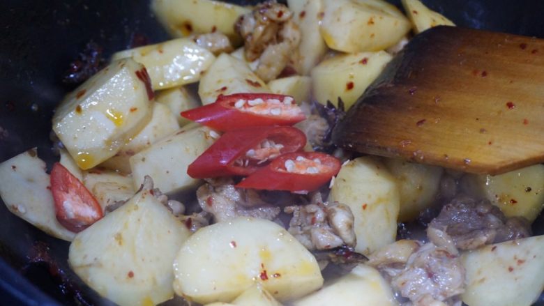 辣烧鸡腿肉,同样土豆也煸炒匀以后,放入美人椒随意翻拌两下。