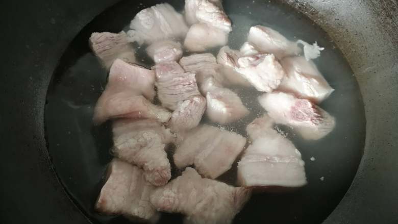 草菇烧肉,热水下五花肉块,煮沸捞起,洗去浮沫沥干备用