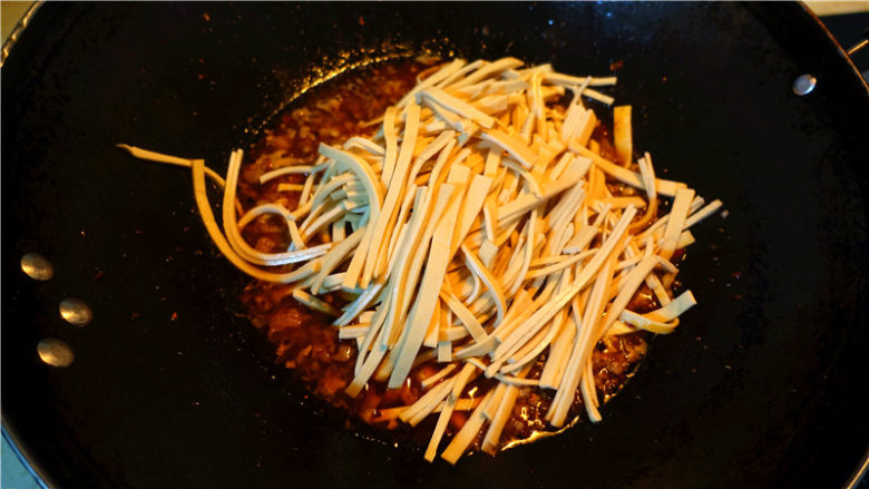 肉末烧豆腐皮,将豆腐皮丝放入锅里,大火烧开,转小火烧制,盖锅盖。