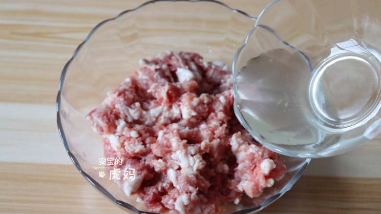 蟹粉狮子头,花椒水分3次加入肉糜中,用筷子同一个方向搅拌均匀;