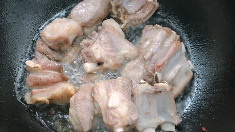 新疆特色羊肉抓饭,重新开大火,放入羊排,炒至变色;