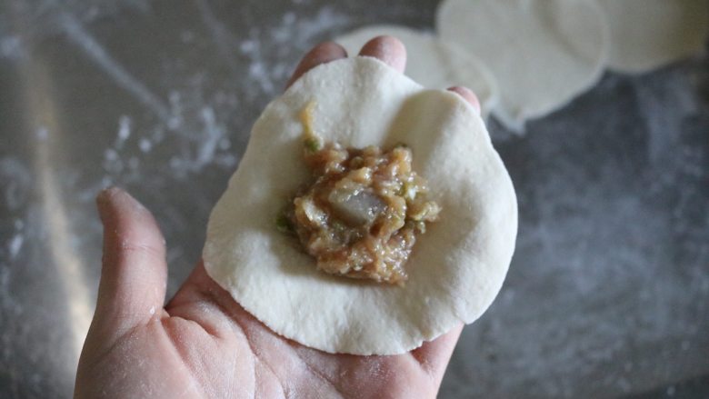 四喜蒸饺,取一个面皮,放入适量肉馅;