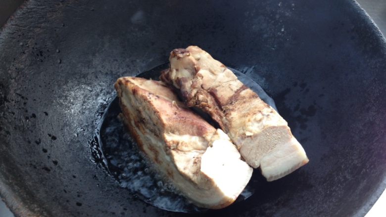 梅菜扣肉,锅中倒入油烧热后放入五花肉，猪皮朝下炸制