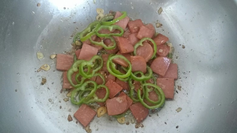 尖椒炒午餐肉,放入尖椒,翻炒均匀。