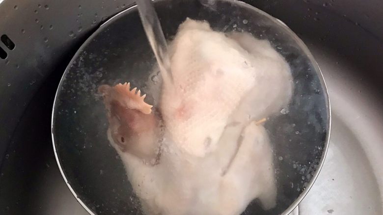砂锅三黄鸡,把三黄鸡捞出来后立即用冷水过凉,洗去浮沫