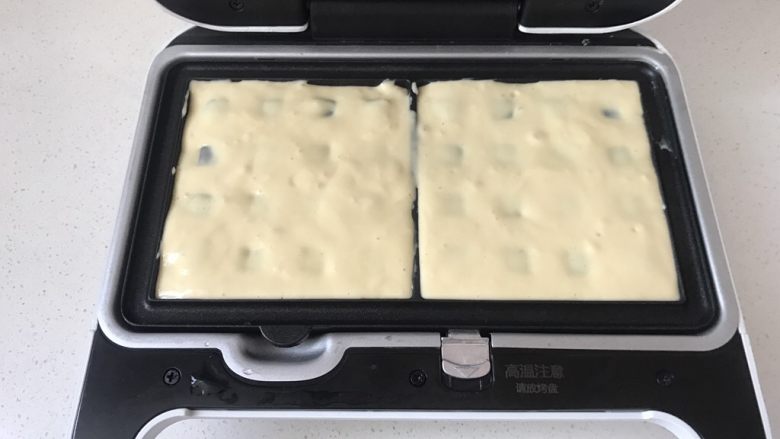 华夫饼(酵母版),在华夫饼模具里抹薄薄一层黄油,将面糊用勺子挖到华夫饼模具里