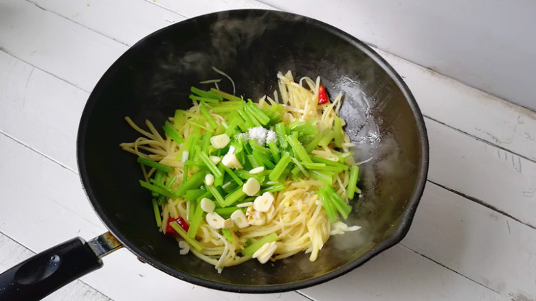 土豆丝炒芹菜,下入芹菜段,盐,蒜片