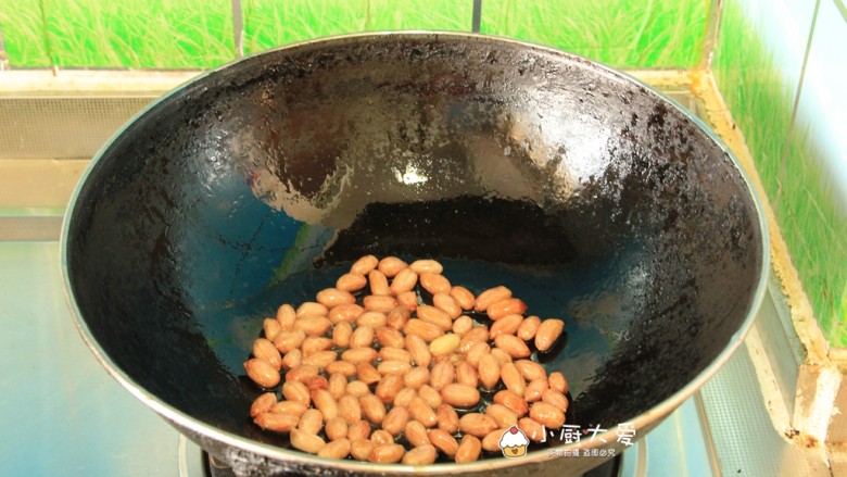 过年开胃菜---酸辣蕨根粉,炒锅烧干后放入适量的食用油，倒入花生仁，小火慢慢炒熟