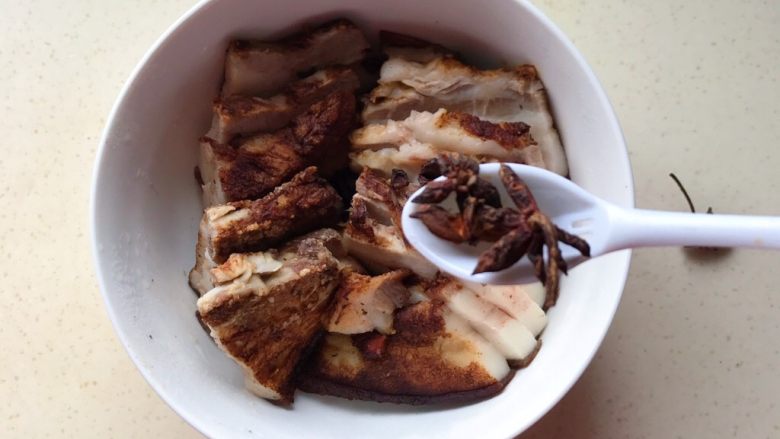 金牌走油五香扣肉,肉皮朝下放入碗中,尽量摆得漂亮一些,上面再次放上桂皮、八角