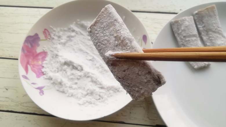 干炸带鱼,将淀粉放在盘内,将带鱼段均匀的沾上一层淀粉