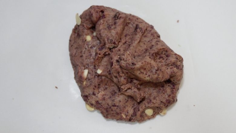 意式紫薯杏仁脆饼,铺一张油纸将面团取出,放在油纸上