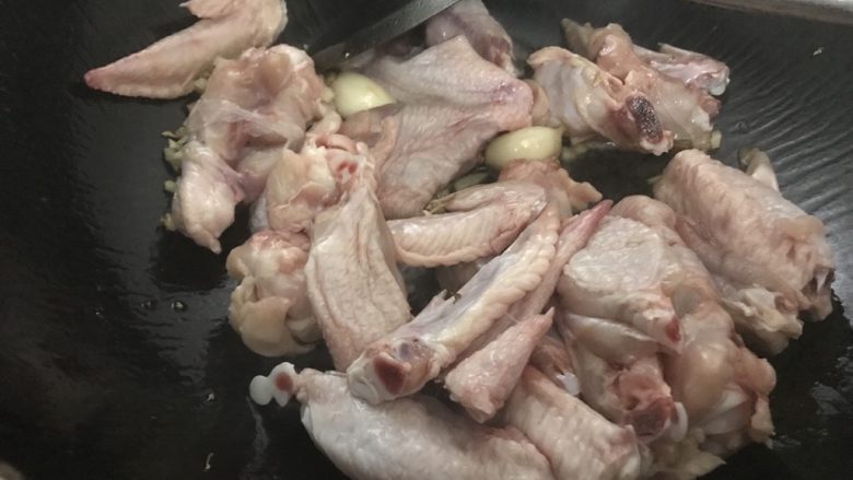 沙姜焖鸡翅,倒入鸡翅,翻炒,炒干水份。
