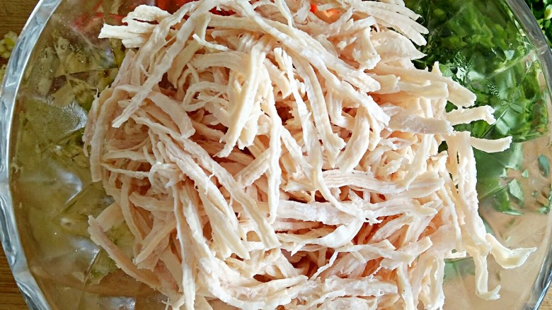 重庆川味冷面鸡,将晾凉的鸡胸肉沿肉的纹理撕成细丝。