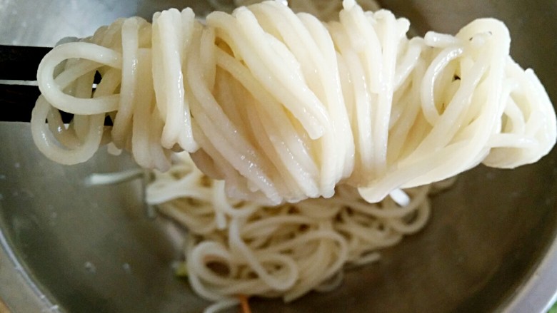 重庆川味冷面鸡,用筷子将煮好的挂面卷成卷儿。