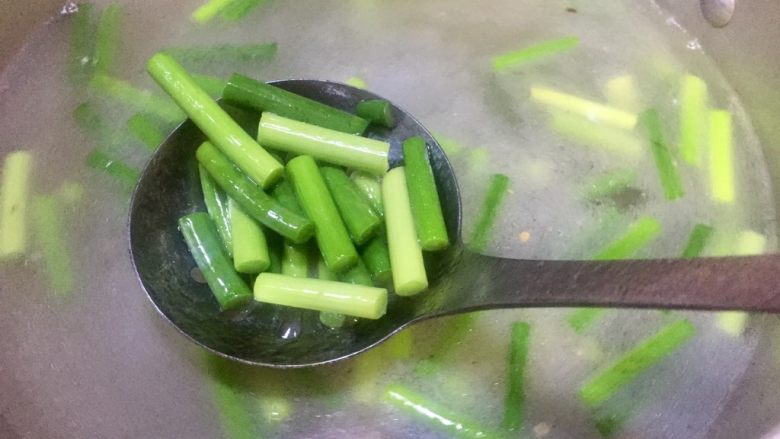 #年味#蒜苔炒腊肉,把蒜苔放入之前煮腊肉的汤汁里焯水,汤汁再次开了就捞出沥水