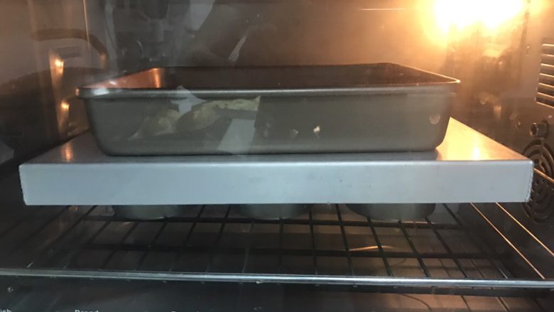 堡尔美克鸡蛋披萨杯,10、盖上一个平底烤盘,上面压一个重一点的模具,38度发酵至八分满。预热烤箱200度上下火,烤箱中下层,烘烤5分钟,用做披萨杯的定型。