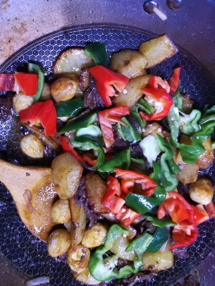 土豆牛肉鹌鹑蛋,最后一步将备好的青红辣椒一起下锅用来回翻炒,这时要加入盐,海鲜酱油,胡椒粉,花椒粉,葱姜蒜一起煸炒至入味,最后盛盘加<a style='color:red;display:inline-block;' href='/shicai/ 756'>鸡精</a>