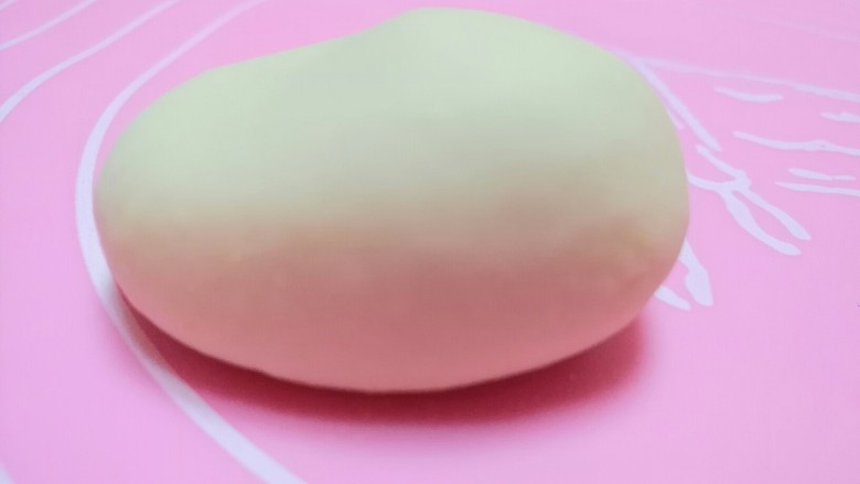 小狗馒头,取26克面团排气揉成椭圆形,在二分之一的地方用食指轻轻按压成如图形状做小狗的头。