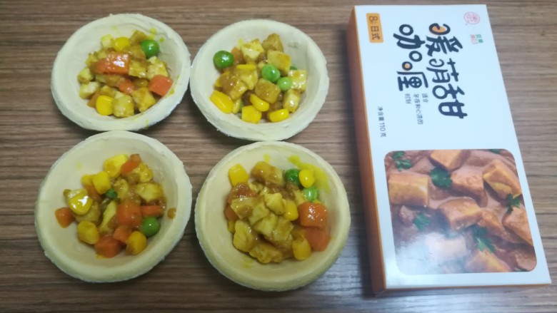 快手鸡肉咖喱塔,将炒好的鸡肉蔬菜丁放入四个塔皮中,不用放满,七分满就可以啦。
