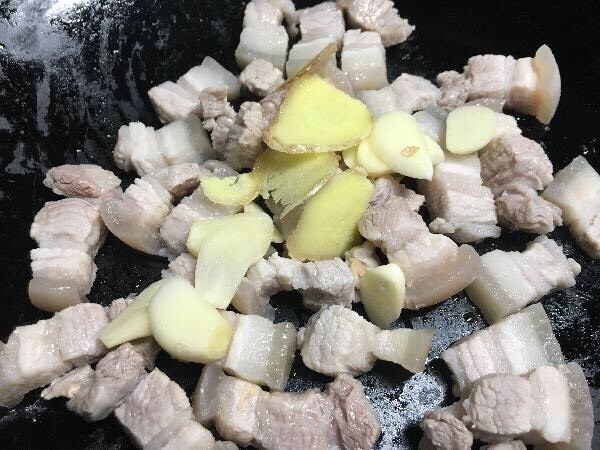 豆角烧肉,锅内放入少许油,把五花肉和葱姜蒜片一起翻炒