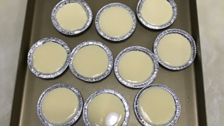 烤布丁,将蛋液均匀的倒入模具,烤盘注入热水。