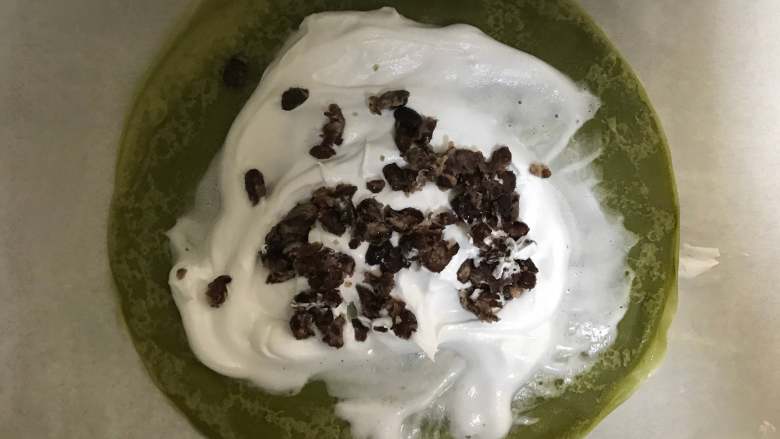抹茶蜜豆千层蛋糕,将一份饼皮放入一个托板上,放入适量奶油,再放下一块饼皮,用手轻轻的按压将奶油在四周挤压均匀
依此类推做完所有饼皮。