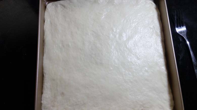 肉松面包卷,放入28×28的烤盘中。把边缘部分整理好, 边缘如果有多余的部分,可以用刀切掉。