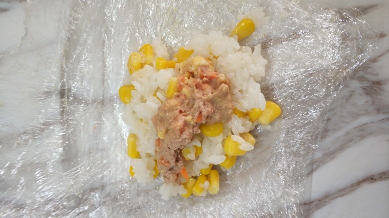 金枪鱼三色饭团,保鲜膜叠三层,放入米饭,中间放入金枪鱼,