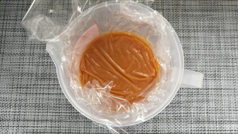 配一脸的焦糖核桃香蕉慕斯,14. 加入泡软的吉利丁片,混合至吉利丁融化,趁热过筛,表面铺保鲜膜,放凉至25度