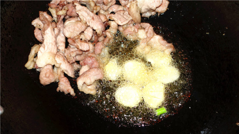 香菇甜椒肉片,就将肉片推到锅边,将蒜片放入锅里的底油里爆香。