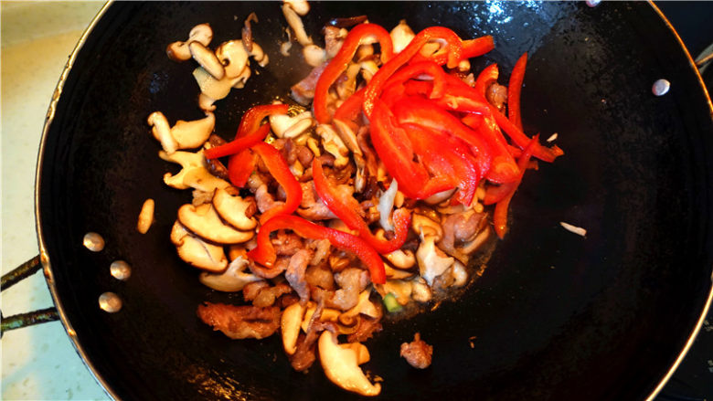 香菇甜椒肉片,将香菇炒至变软出水,放入甜椒丝翻炒。