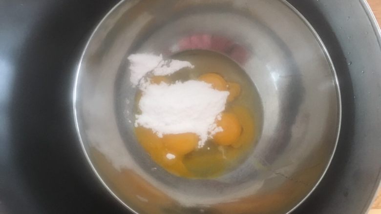 蜂蜜凹蛋糕,准备一个大一点的料理盆,加热水,把蛋液料理盆放进去,让蛋液加热到40度左右。这样得温度最适合全蛋打发。
