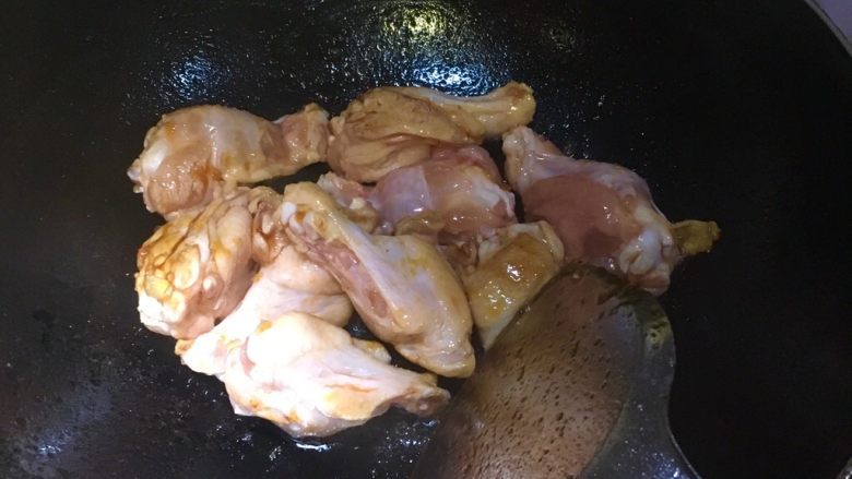 红烧鸡翅根,倒入翅根炒糖色，炒到翅根均匀上色