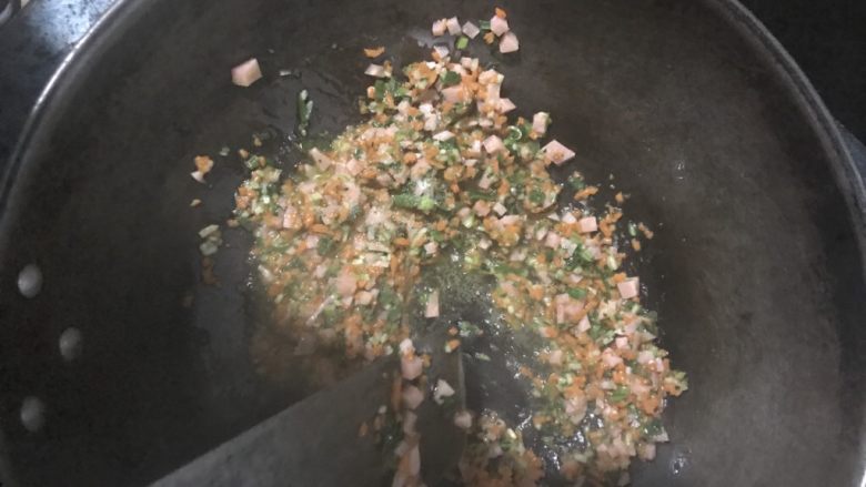 饭团,下入所有的菜丁和香肠丁，翻炒片刻，加入少量盐。