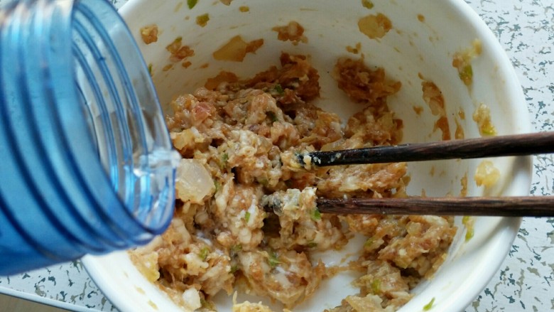 酸菜馅饺子,加入少量的水,然后开始朝一个方向搅拌,搅到肉开始发黏,感觉吃力时再加入少量的水,如此循环,直到肉搅再也不吃力为止。