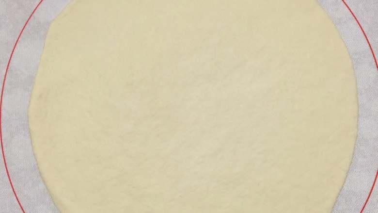海鲜披萨,将发酵好面团取出进行排气,擀成略大于25厘米的圆形。