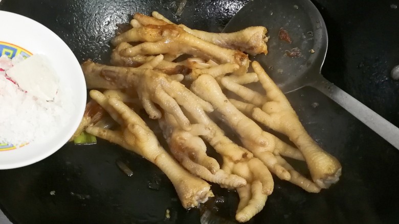 冷热两吃糯弹冰糖生抽香凤爪,放入冰糖翻炒融化至浅咖啡色