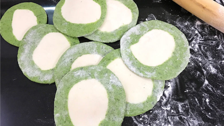 翡翠饺子,然后取一个剂子按扁,擀成四周薄中间厚的饺子皮。