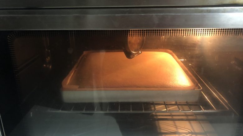 奶油蛋糕卷,烤盘在操作台上磕几下送入提前预热好的烤箱,上下火150度烤30分钟。