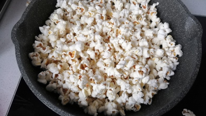春节零食~奶油焦糖爆米花,待锅内无爆裂声音后打开锅盖;
将爆好的爆米花倒出备用;