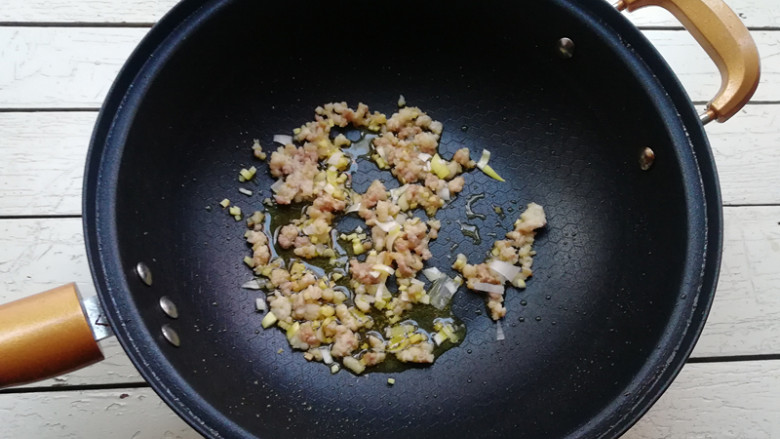 肉末烧茄条,下入葱花,姜末炒香