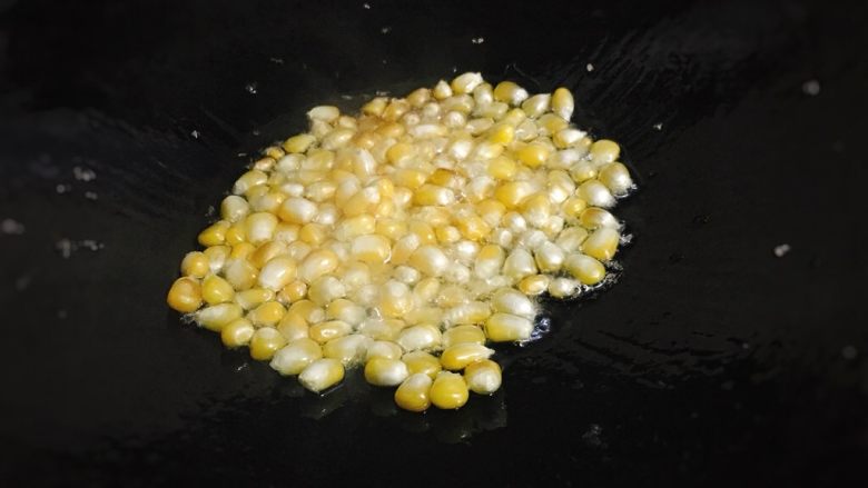 五彩玉米火腿炒饭,锅内放入少许食用油,中火加热至6成热,倒入玉米粒翻炒。