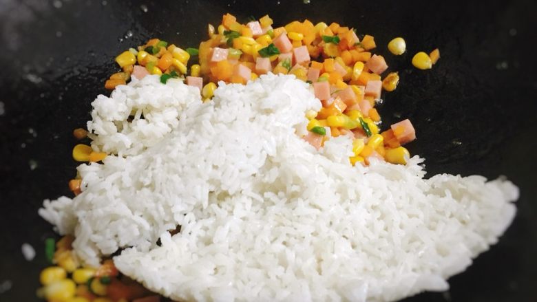 五彩玉米火腿炒饭,转小火,放入<a style='color:red;display:inline-block;' href='/shicai/ 507'>米饭</a>。