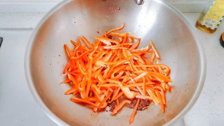 豆瓣酱炒双椒,下红辣椒丝，转大火，翻炒。因为我的青椒偏软，不是那种硬的牛角尖，所以是分开放的。如果青椒偏硬，就一起放。